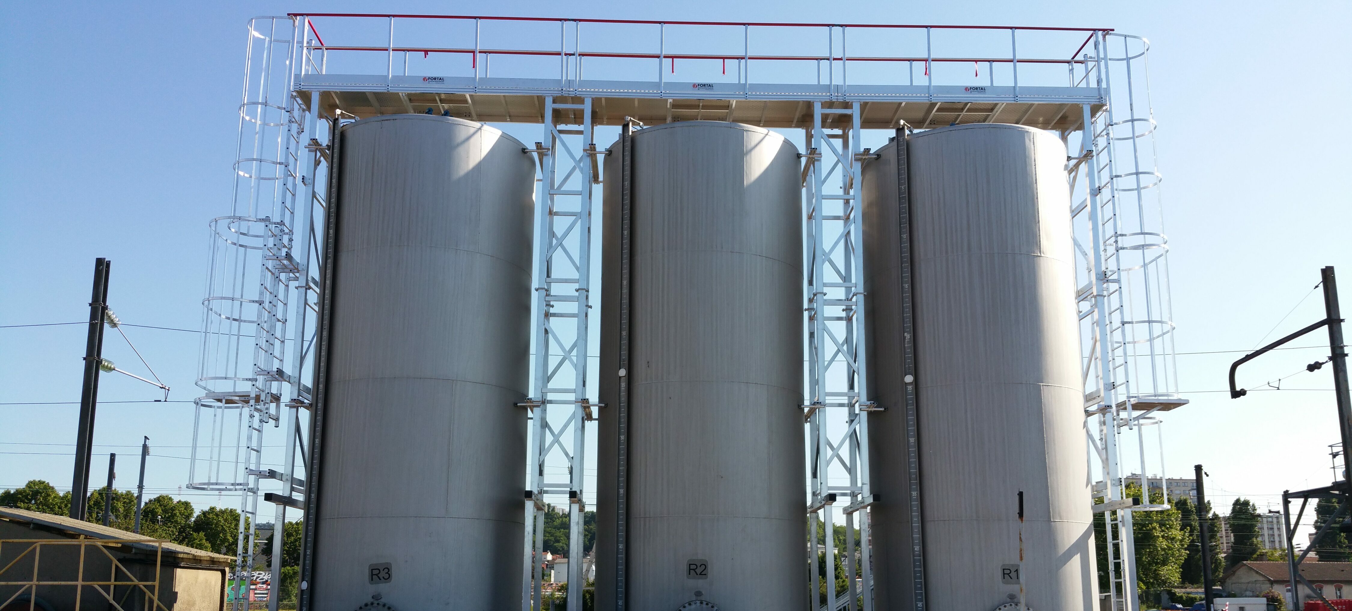 échelles à crinoline avec passerelle sur silos pétrochimiques